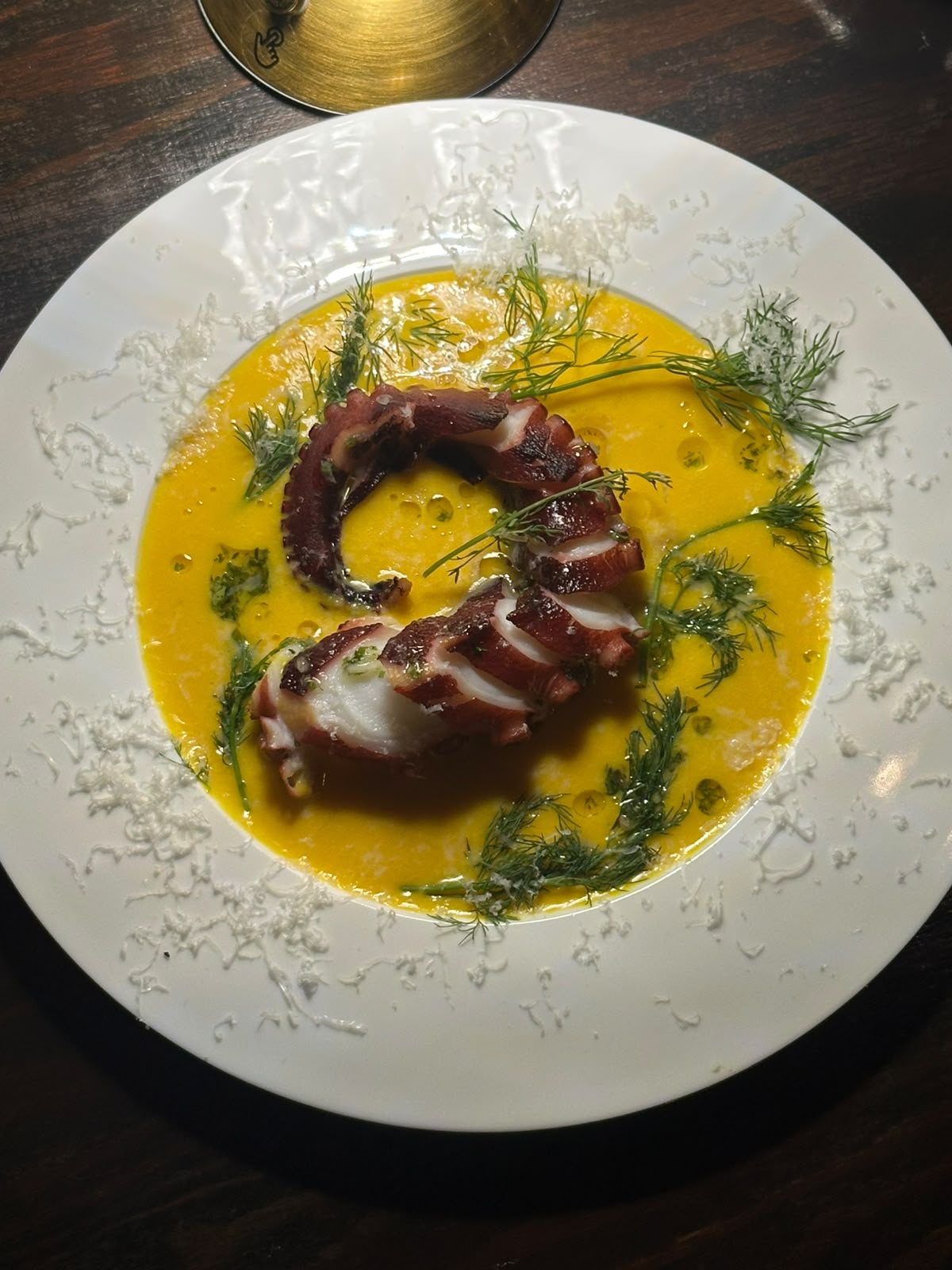 A test dish plated in a vivid golden sauce