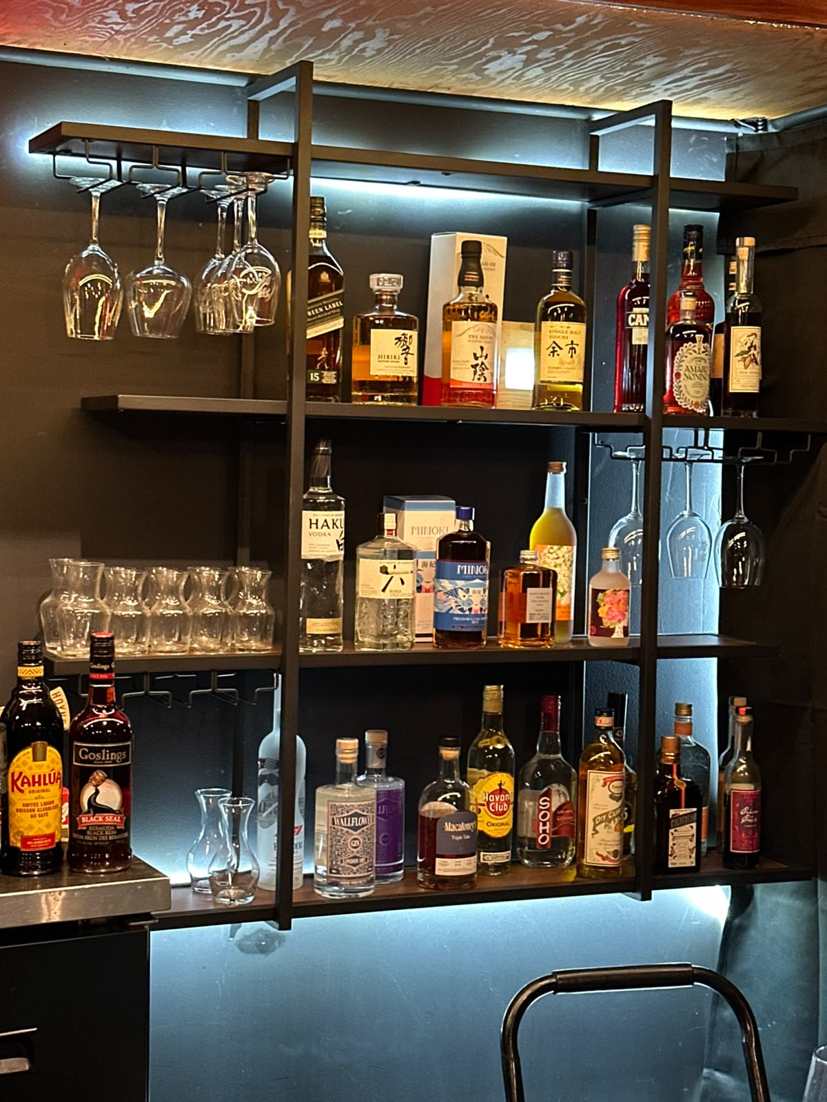 Bottles and hanging glasses behind the Muse bar